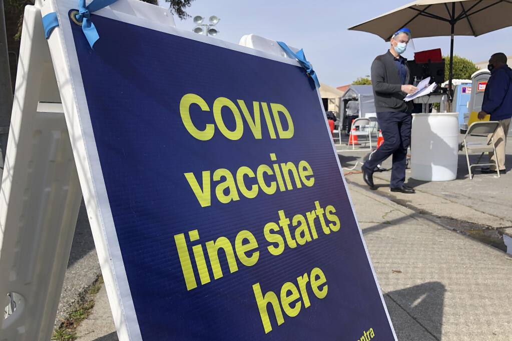 FILE - In this Feb. 8, 2021 file photo, a sign is shown at a COVID-19 vaccine site in the Bayview neighborhood of San Francisco. San Francisco is the latest California city to temporarily shutter a mass vaccination site due to lack of vaccine, joining Los Angeles in pausing inoculations amid a national shortage. Officials said mass vaccinations are on hold at Moscone convention center for one week until supply ramps up. On Tuesday, Feb. 16 two new mass vaccination sites with doses from the federal government will open in Oakland and in Los Angeles. (AP Photo/Haven Daley, File)