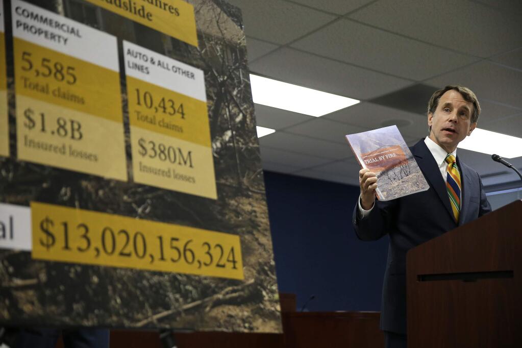 California Insurance Commissioner Dave Jones holds up a report during a news conference about the costs of recent wildfires Thursday, Sept. 6, 2018, in San Francisco. Jones released the first data on the total insurance claims reported for residential and commercial losses following the Carr and Mendocino Complex wildfires. Commissioner Jones also released updated data for the 2017 California wildfires and 2018 mudslides. The number at left is the grand total of insured losses from the 2017 wildfires and Montecito mudslide. (AP Photo/Eric Risberg)