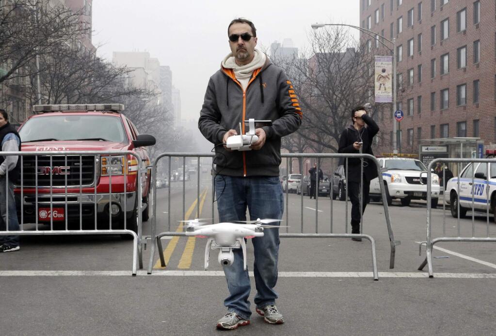 In this March 12, 2014 file photo, Brian Wilson launches a small drone equipped with a video camera to fly over the scene of an explosion that leveled two apartment buildings in the East Harlem neighborhood of New York. (AP Photo/Mark Lennihan, File)