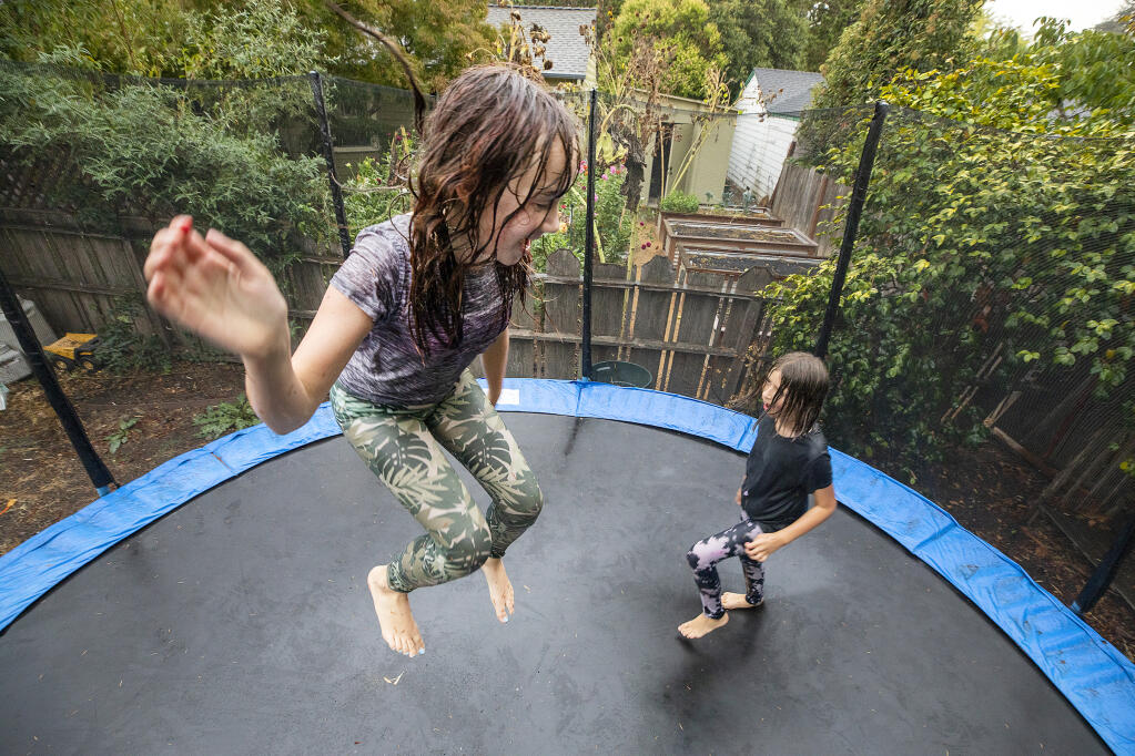 Ari Leibert, 9, left, and Matilda Wilson, 10, ran outside to jump on their trampoline when the rain started early evening on on Monday, Sept. 27, 2021. The pair told their parents "we're not coming inside, it's finally raining." (John Burgess / The Press Democrat)