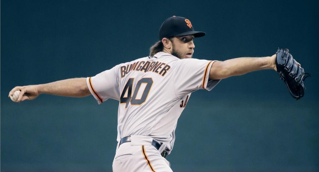 San Francisco Giants starting pitcher Madison Bumgarner throws during the first inning of the team's game against the Kansas City Royals on Wednesday, April 19, 2017, in Kansas City, Mo. (AP Photo/Charlie Riedel)