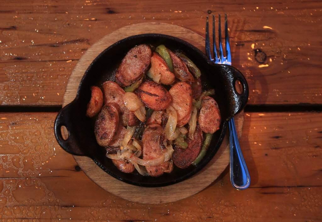 Grilled sausages with roasted sweet peppers pairs with our wine of the week, Markham Vineyards 2014 Napa Valley Merlot. (Kent Porter/The Press Democrat)