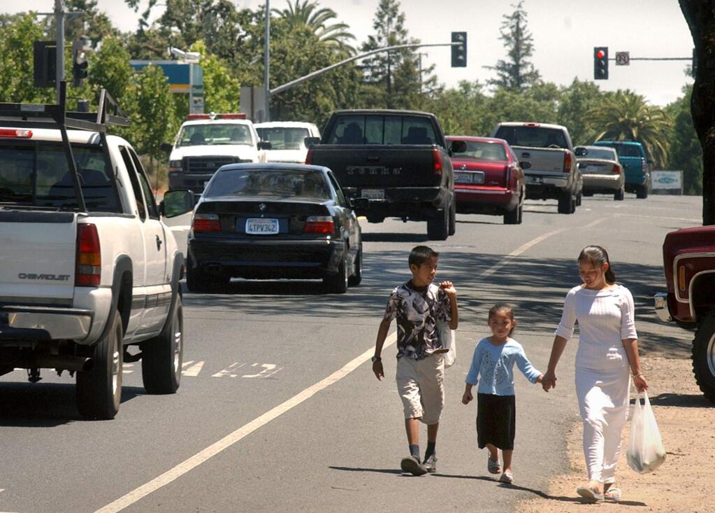 Pedestrians walk along Highway 12 in Sonoma Valley in 2004. (PD FILE)