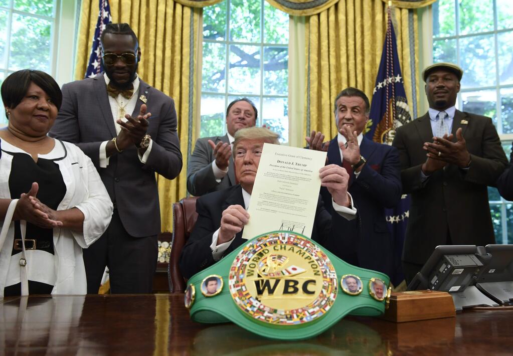 President Donald Trump posthumously pardoned Jack Johnson, boxing's first black heavyweight champion, on May 24. Trump was joined in the Oval Office by Linda Haywood, who is Johnson's great-great niece; heavyweight champion Deontay Wilder; Keith Frankel; Sylvester Stallone; and former heavyweight champion Lennox Lewis. (SUSAN WALSH / Associated Press)