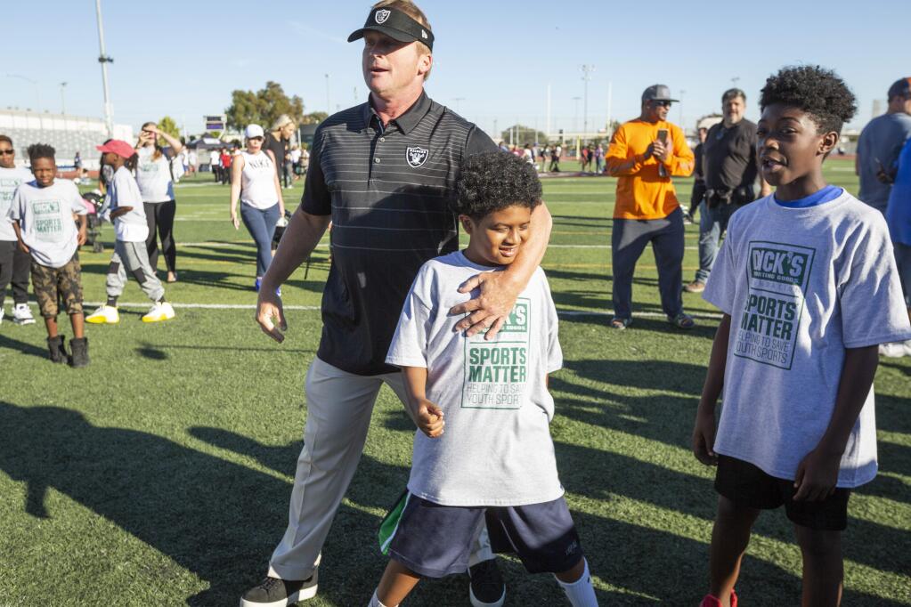 Oakland Raiders coach Jon Gruden runs through drills with players from four Oakland-area youth football leagues after overseeing the distribution of funds and equipment through the DICK'S Sporting Goods Sports Matter Program in San Leandro, Tuesday, July 17, 2018. (Eric Kayne/AP Images for DICK'S Sporting Goods)