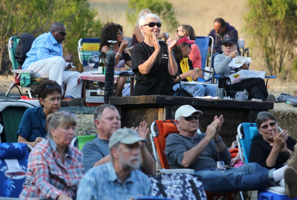 Linda Pavlak, center, cheers on her husband Bill Myers, event coordinator for Funky Fridays, as he announces the band Sugarfoot who performed during the summer concert series held at Sugarloaf Ridge State Park Amphitheater in Kenwood, Friday, July 31, 2015. (Crista Jeremiason / The Press Democrat)