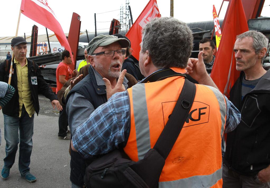 Union activists block the entrance of the industrial area in Boucau, near Bayonne, southwestern France, on a day of nationwide strikes and protests over a labor reform, Thursday, May 26, 2016. French Prime Minister Manuel Valls says he is open to improvements and modificationsin a labor bill that has sparked intensifying strikes and protests, but will not abandon it. (AP Photo/Bob Edme)