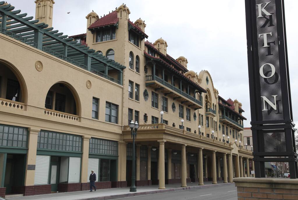 In this Feb. 29, 2012, file photo, a man walks past the historic Hotel Stockton in Stockton, Calif, which gave several dozen families $500 a month for a year as part of a program to study the economic and social impacts of giving people a basic income. (AP Photo/Ben Margot, File)