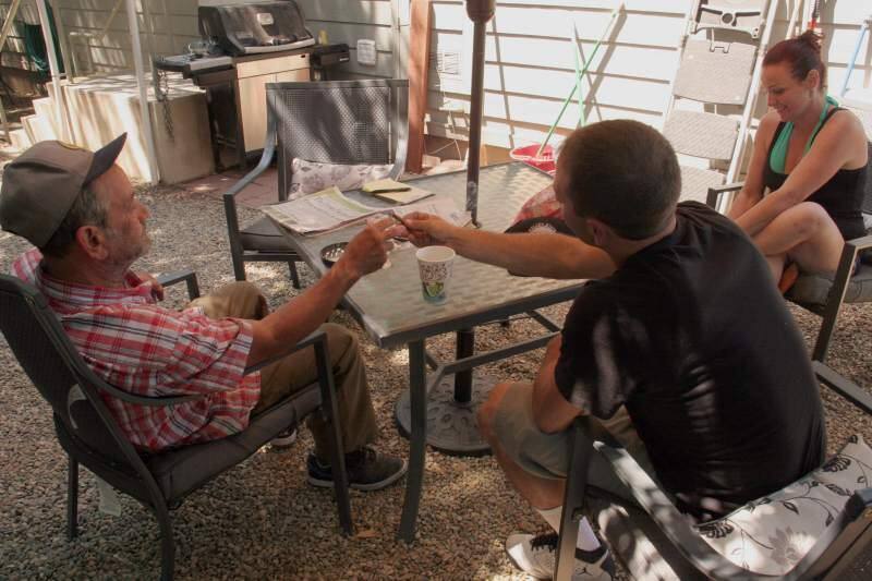 Three Sonoma locals share conversation and a cigarillo in the back yard of the Haven's First Street West location, where many of the area's homeless come for lunch, laundry and other essential services. This photo was taken as part of a front-page story on the shelter's day services that ran in the 'Index-Tribune' in 2017. (Christian Kallen/Index-Tribune)