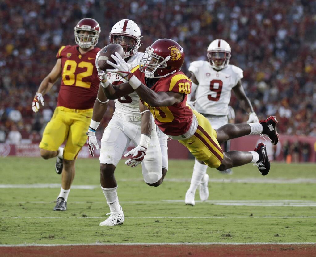 USC's Deontay Burnett, center, catches a touchdown pass against Stanford, Saturday, Sept. 9, 2017, in Los Angeles. (AP Photo/Jae C. Hong)