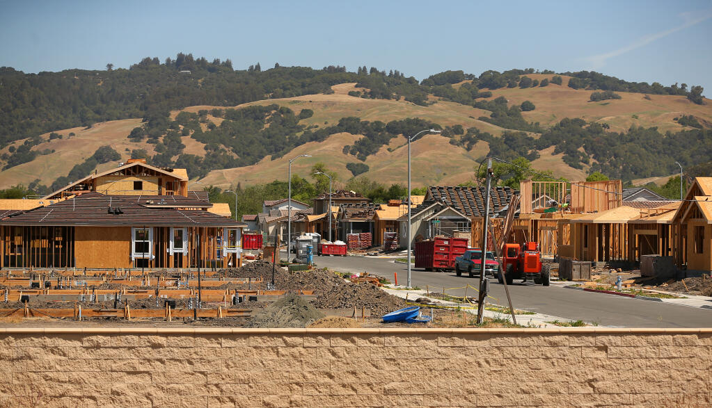 Workers build single family homes in the Love Oak development by KB Homes in Rohnert Park on Tuesday, May 11, 2021. (Christopher Chung/ The Press Democrat)