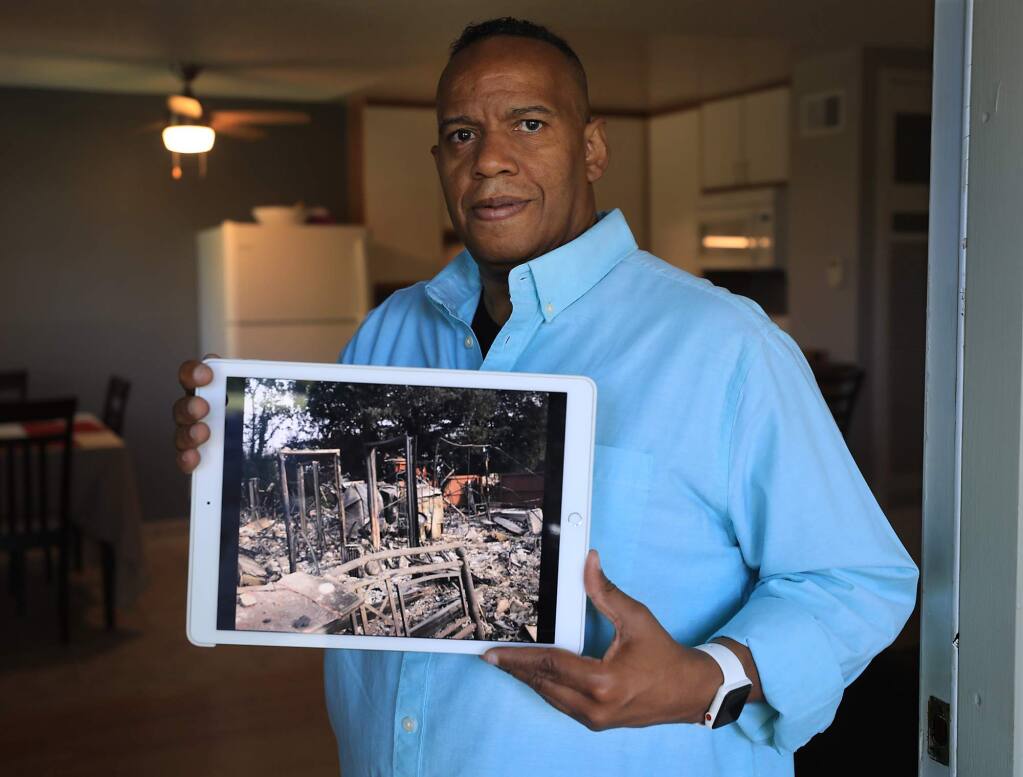 Michael Newton rented a place at Hopper Lane Apartments in Santa Rosa, and was burned from his residence during the Tubbs fire last October, now renting in Rohnert Park/Cotati, Newton shows a picture of his place in which he remembers the amount of doorways that were still standing. Rebuilding Our Community (ROC) aided Newton after physical and financial setbacks left him with little or no income that helped to pay for a security deposit on his new apartment (Kent Porter / The Press Democrat) 2018