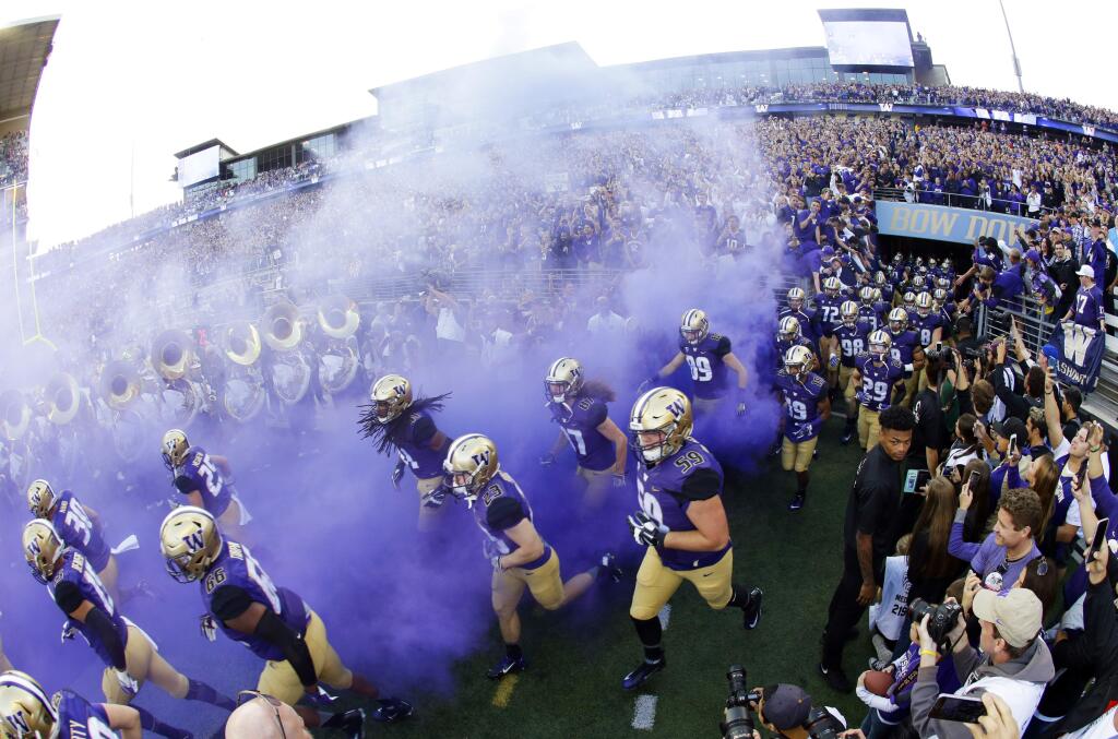 Washington players run out of the tunnel at the start of an NCAA college football game against Stanford, Friday, Sept. 30, 2016, in Seattle. (AP Photo/Ted S. Warren)