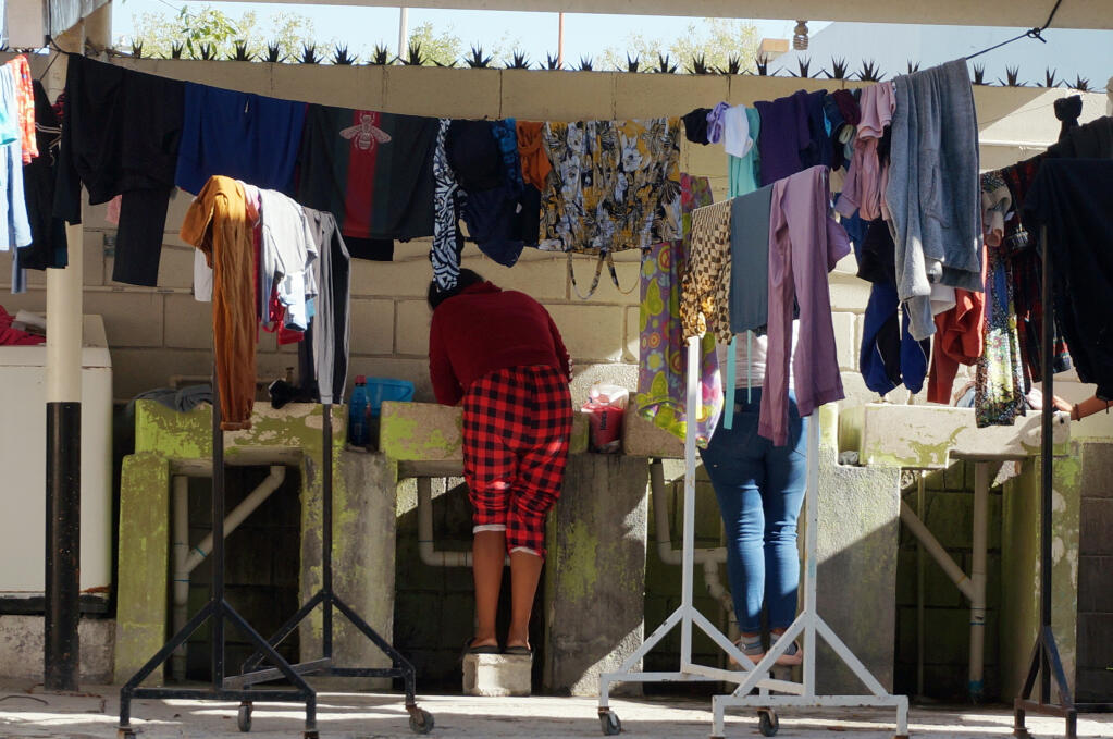 Migrant women wash clothes at the Casa del Migrante shelter run by Catholic nuns in Reynosa, Mexico, Thursday, Dec. 15, 2022. (AP Photo/Giovanna Dell'Orto)