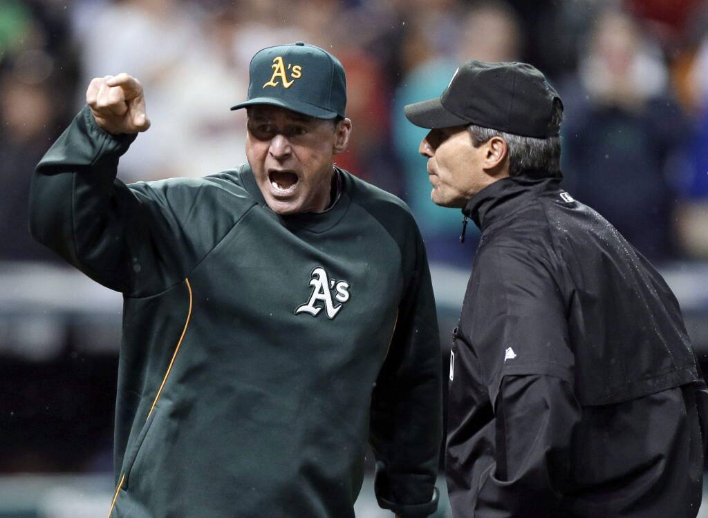 Oakland Athletics manager Bob Melvin, left, argues with umpire Angel Hernandez after a review failed to turn a double by Adam Rosales into a home run in the ninth inning of a game against the Cleveland Indians on Wednesday, May 8, 2013. Melvin was ejected. The Indians won 4-3. (AP Photo/Mark Duncan)