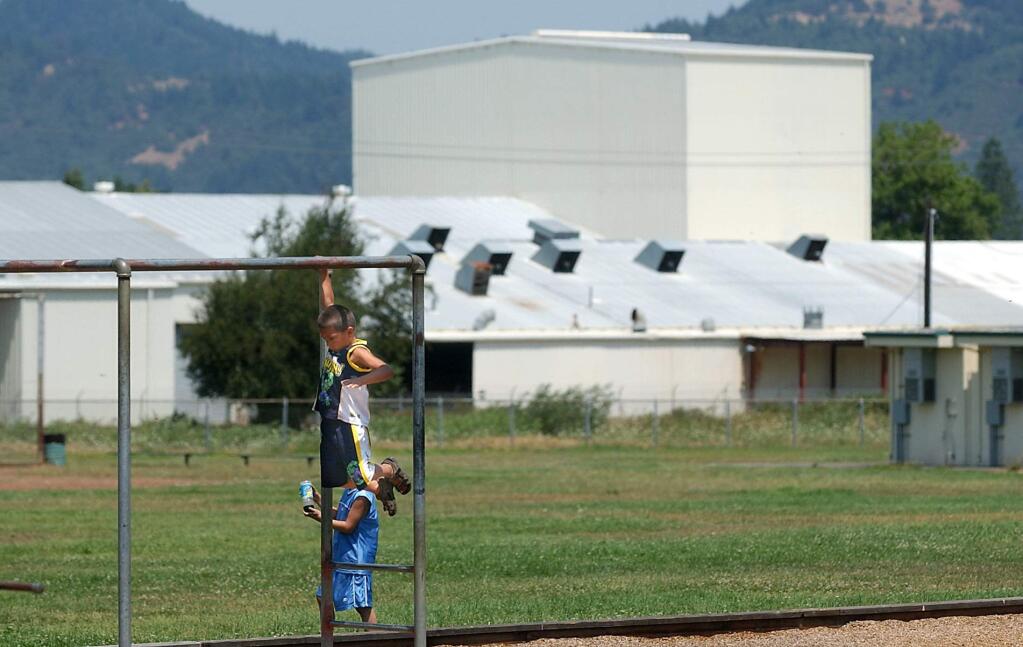 3/14/2009:B1: Children play at Baechtel Grove Middle School in Willits, which sits next to the Remco plant, seen in the background. PC: Nicholas Hearon of Willits plays on the playground equipment at the Baechtel Grove Middle School in Willits, Thursday July 31, 2003. The Remco plant can be seen in the background.