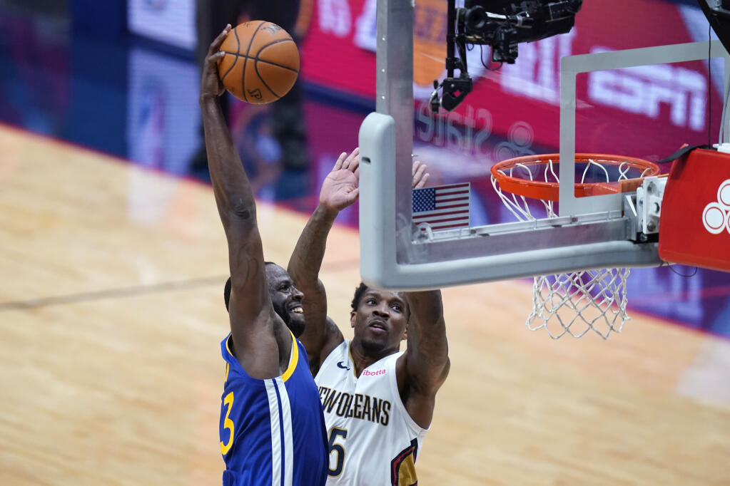 Golden State Warriors forward Draymond Green slam dunks against New Orleans Pelicans guard Eric Bledsoe (5) in the first half of an NBA basketball game in New Orleans, Monday, May 3, 2021. (AP Photo/Gerald Herbert)