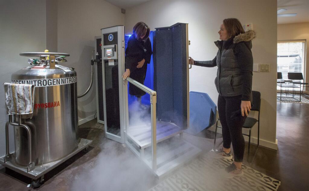 Taylor Serres helps Barbara Chatham into the cryotherapy chamber at Sonoma Cryo. It's Chtham's second session in as many days. (Photo by Robbi Pengelly/Index-Tribune)