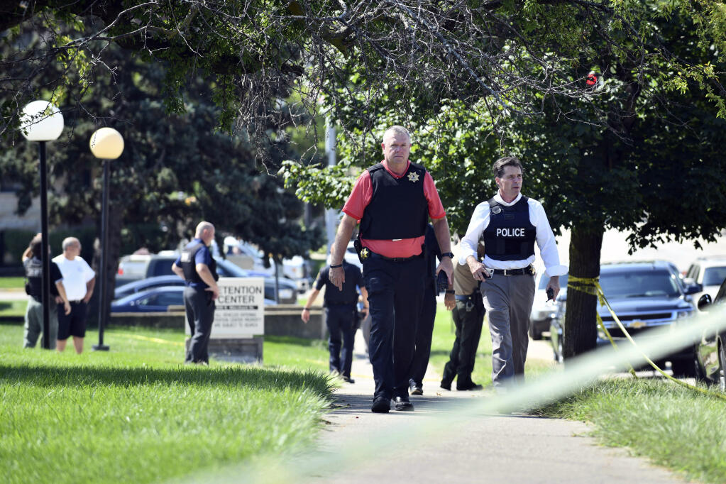 Kankakee County Sheriff Mike Downey, left, and Kankakee Police Chief Robin Passwarer  follow a shooting near the Kankakee County Courthouse, Thursday morning, Aug. 26, 2021, in Kankakee, Ill. Two people were killed and another was injured Thursday morning, Mayor Christopher Curtis said. (Tiffany Blanchette/The Daily Journal via AP)
