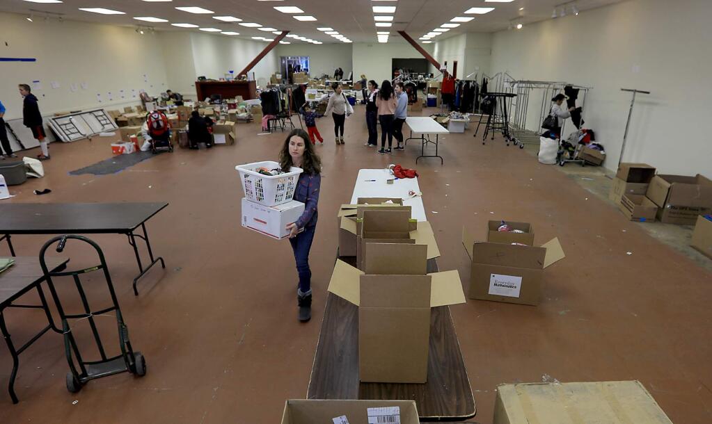 Volunteer Tara Veal helps to pack donated items, Wednesday Dec. 27, 2017 as a downtown Santa Rosa donation center for fire victims is being closed. (Kent Porter / The Press Democrat) 2017