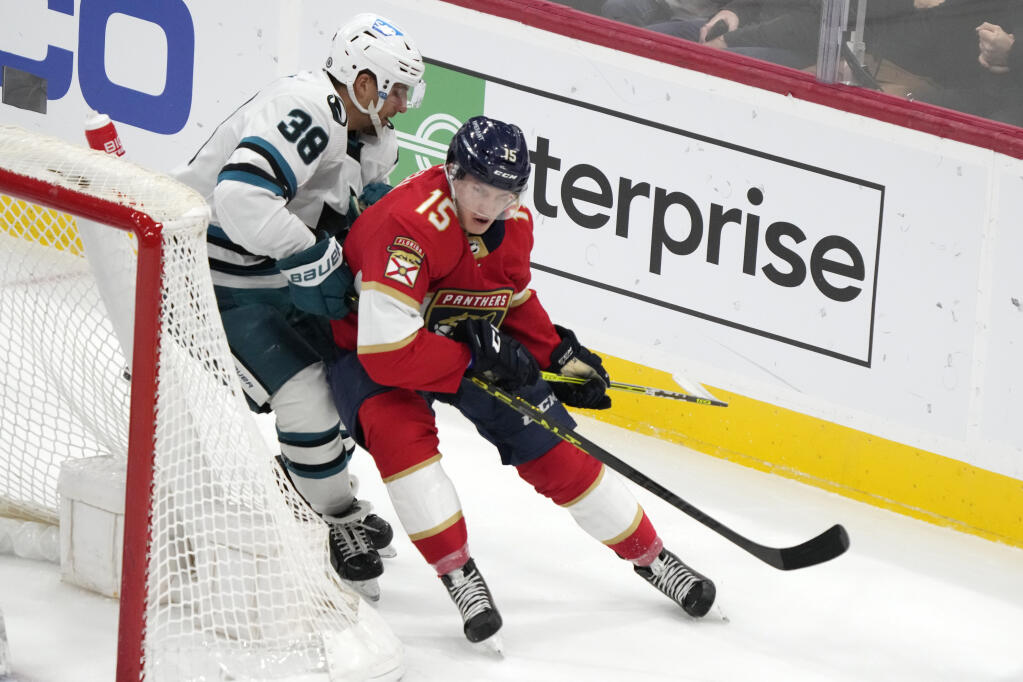 Florida Panthers center Anton Lundell and San Jose Sharks defenseman Mario Ferraro round the net during the second period Thursday, Feb. 9, 2023, in Sunrise, Florida. (Wilfredo Lee / ASSOCIATED PRESS)