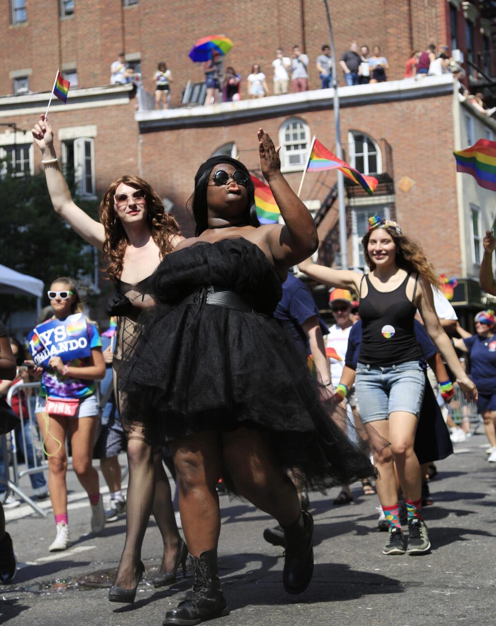FILE - In this June 26, 2016 file photo, a woman blows kisses as she marches in New York City's annual pride parade. The annual pride parade takes place on Sunday, June 25, 2017, amid protests by black and brown LGBT people saying increasingly corporate pride celebrations prioritize the experiences of gay white men and ignore the issues continuing to face black and brown LGBT people. (AP Photo/Seth Wenig, File)