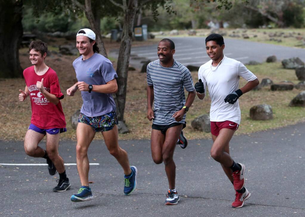 Jonny Vargas, right, a freshman at Santa Rosa Junior College, runs with coach Reesey Byers, P.J. Lynch, and Connor Efstathiu during a workout at Spring Lake Regional Park in Santa Rosa on Tuesday, Oct. 9, 2018. (Beth Schlanker/ The Press Democrat)