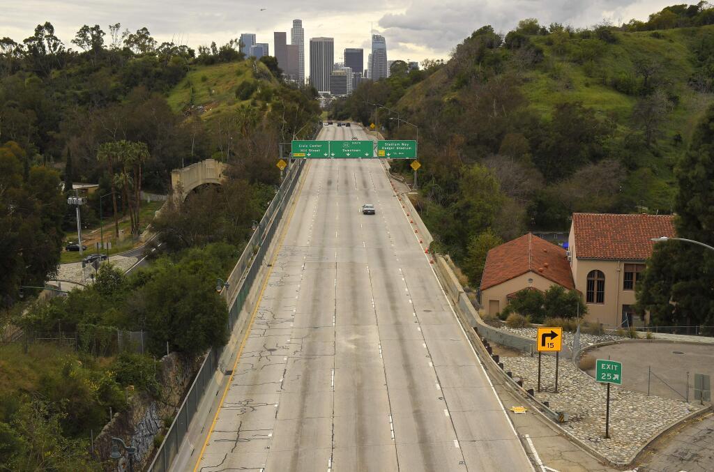 Extremely light traffic moves along the 110 Harbor Freeway toward downtown mid afternoon, Friday, March 20, 2020, in Los Angeles. (Mark J. Terrill/Associated Press)