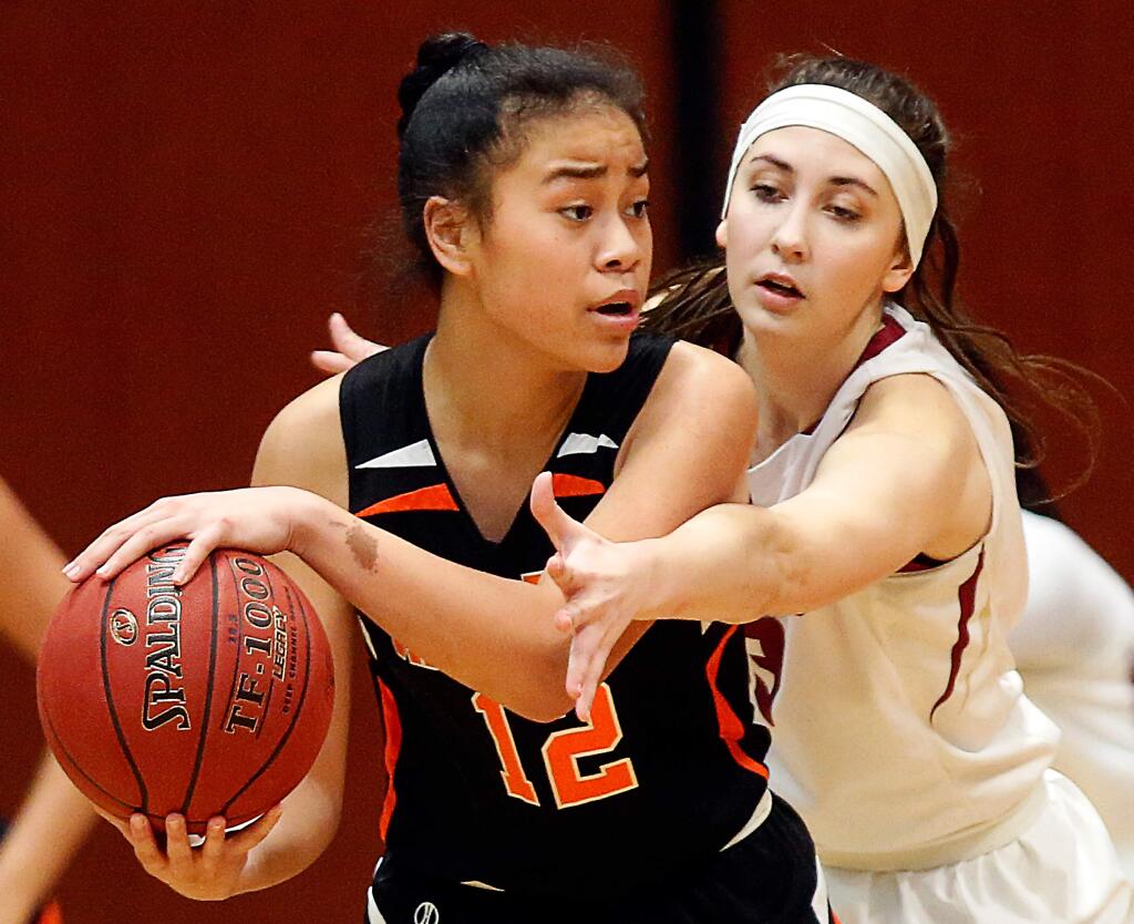 Santa Rosa's Princess Tufele (12) tries to keep the ball away from Cardinal Newman's Hailey Vice-Neat (13) during the first half of the North Bay League tournament girls basketball championship game between Cardinal Newman and Santa Rosa high schools at Haehl Pavilion in Santa Rosa, California on Friday, February 17, 2017. (Alvin Jornada / The Press Democrat)