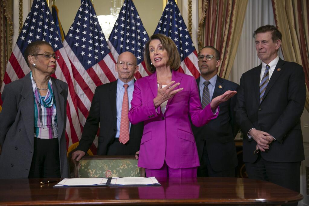 Speaker of the House Nancy Pelosi, D-Calif., talks to reporters after signing a House-passed a bill requiring that all government workers receive retroactive pay after the partial shutdown ends, at the Capitol in Washington, Friday, Jan. 11, 2019. She is joined by, from left, Delegate Eleanor Holmes Norton, D-D.C., Rep. Peter DeFazio, D-Ore., Rep. Anthony Brown, D-Md., and Rep. Don Beyer D-Va. (AP Photo/J. Scott Applewhite)