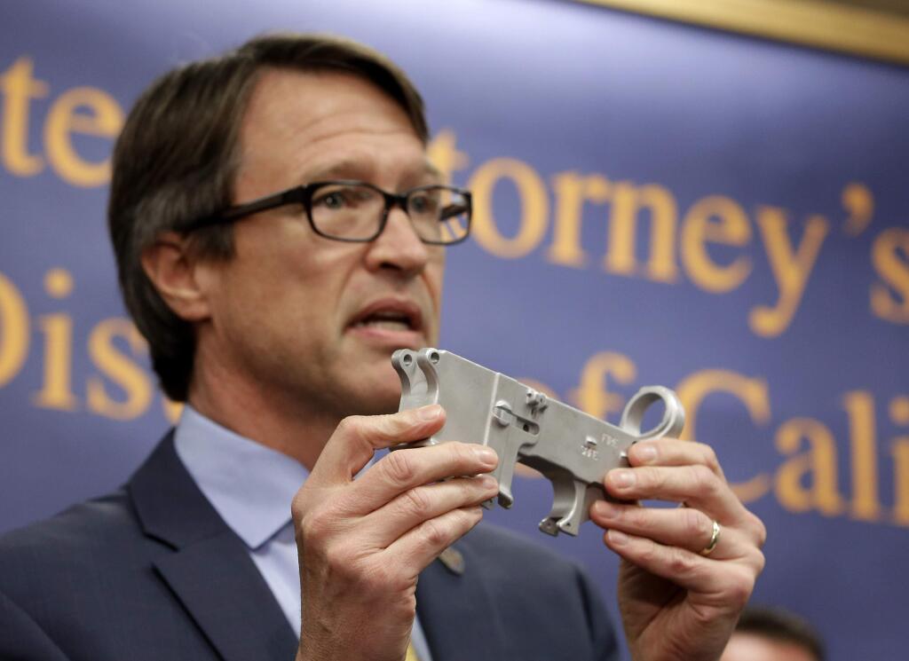 Benjamin Wagner, the United States Attorney for the Eastern District of California, displays a firearm part that can be used to make an untraceable assault-style weapon.(RICH PEDRONCELLI / Associated Press)