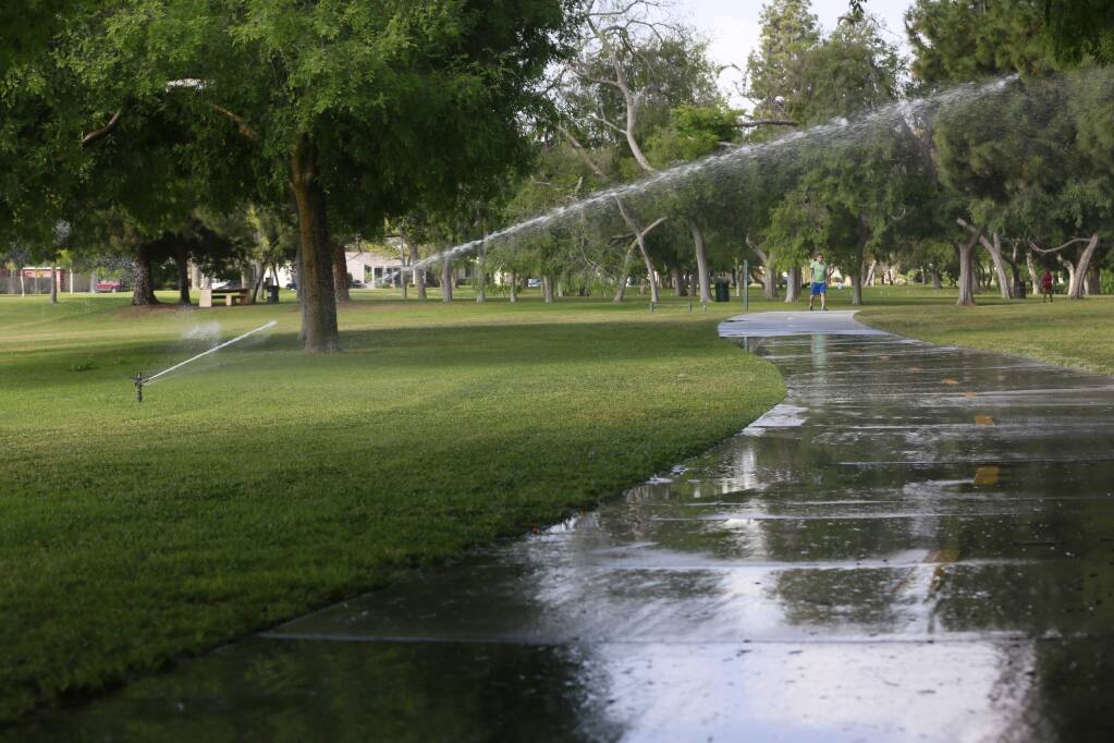 Water sprinklers are used at Heartwell Park in Long Beach, Calif., on Thursday, April 2, 2015. (AP Photo/Nick Ut)