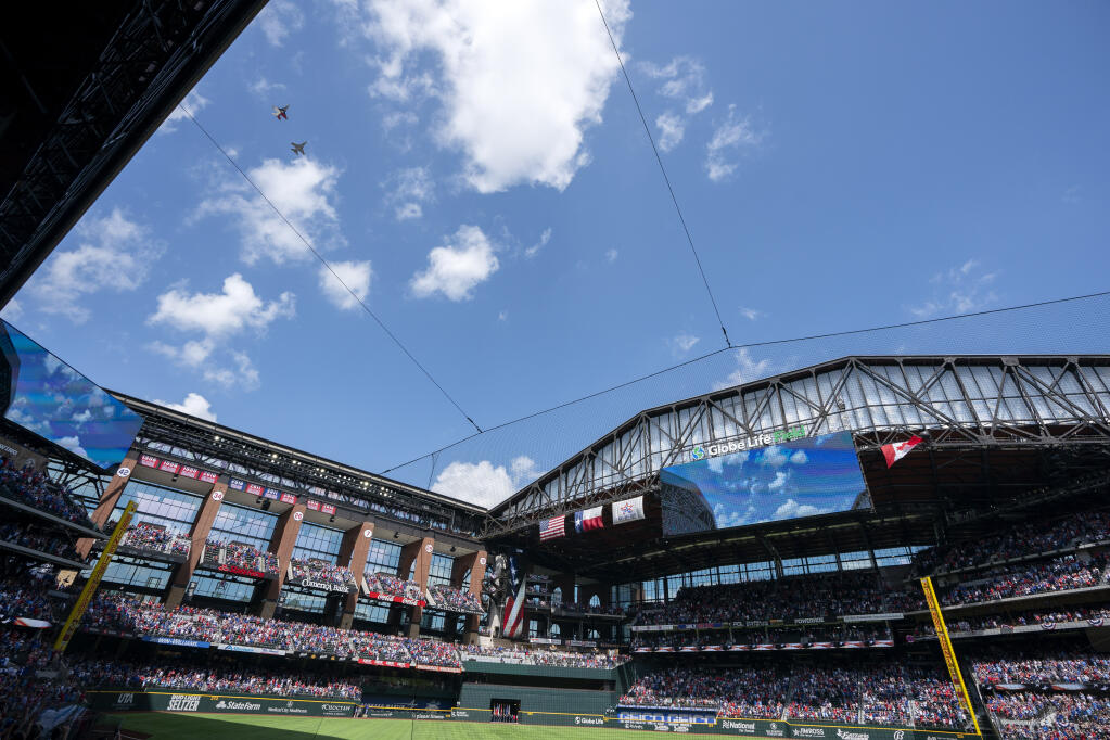 Two F-16 jets fly over Globe Life Field before a baseball game between the Texas Rangers and the Toronto Blue Jays Monday, April 5, 2021, in Arlington, Texas. The Texas Rangers are set to have the closest thing to a full stadium in pro sports since the coronavirus shut down more than a year ago. (AP Photo/Jeffrey McWhorter)