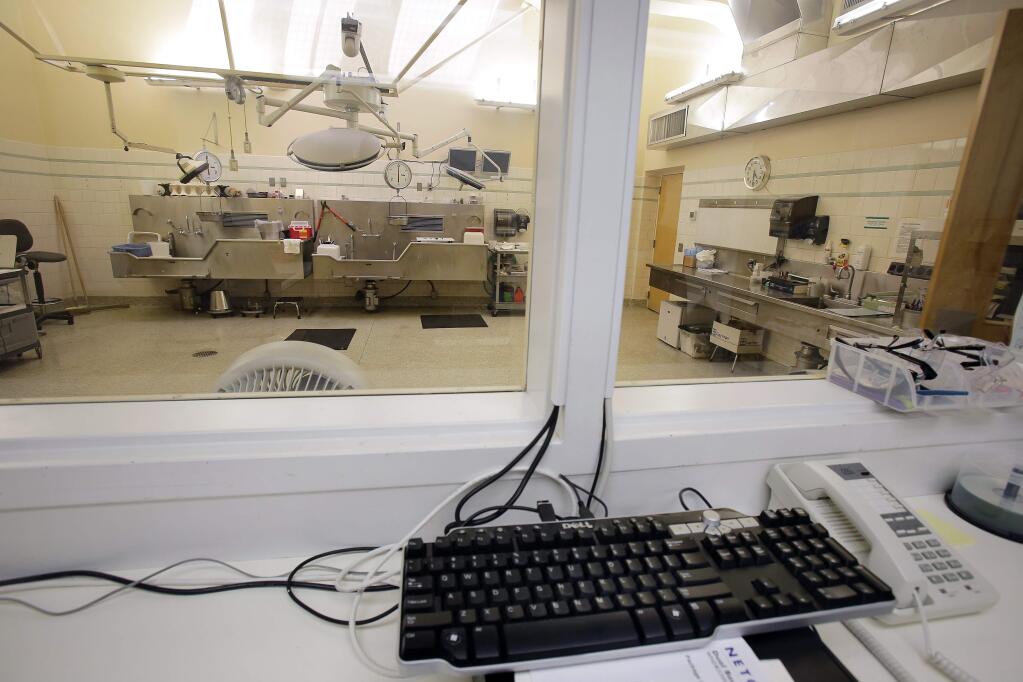 Cameras installed above the lights over the Sonoma County Coroner's operating theater allow detectives and investigators to watch autopsies in the next room in Santa Rosa on Thursday, August 7, 2014. (Conner Jay/The Press Democrat)