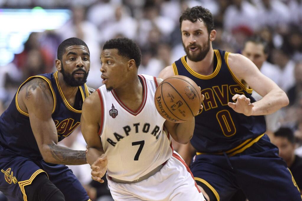 Toronto Raptors guard Kyle Lowry (7) controls the ball as Cleveland Cavaliers forward Kevin Love (0) and Cleveland Cavaliers guard Kyrie Irving defend during second half Eastern Conference final playoff basketball action in Toronto on Monday, May 23, 2016. (Frank Gunn/The Canadian Press via AP) MANDATORY CREDIT