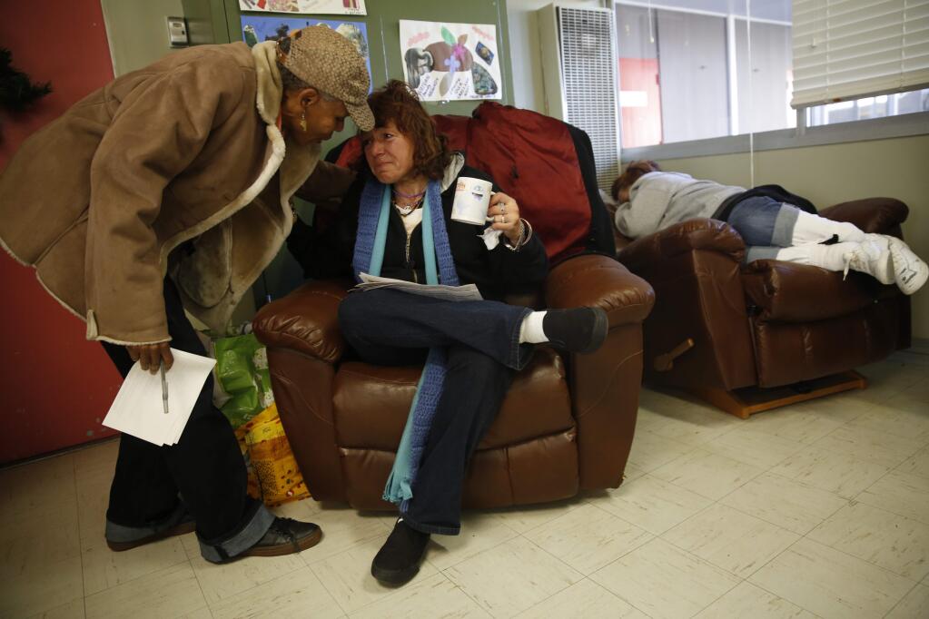 Women's program coordinator Celeste Austin, left, comforts Carol Swann at the Living Room in Santa Rosa, California on Wednesday, December 31, 2014. (BETH SCHLANKER/ The Press Democrat)
