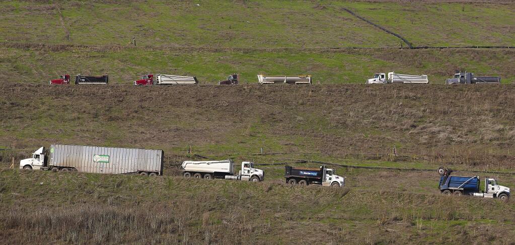 A truck carrying household waste, left, passes trucks waiting to exit the the Republic Services of Sonoma County Inc. central landfill facility after dumping their loads of fire debris near Cotati on Tuesday, Nov. 21, 2017. (CHRISTOPHER CHUNG/ PD)