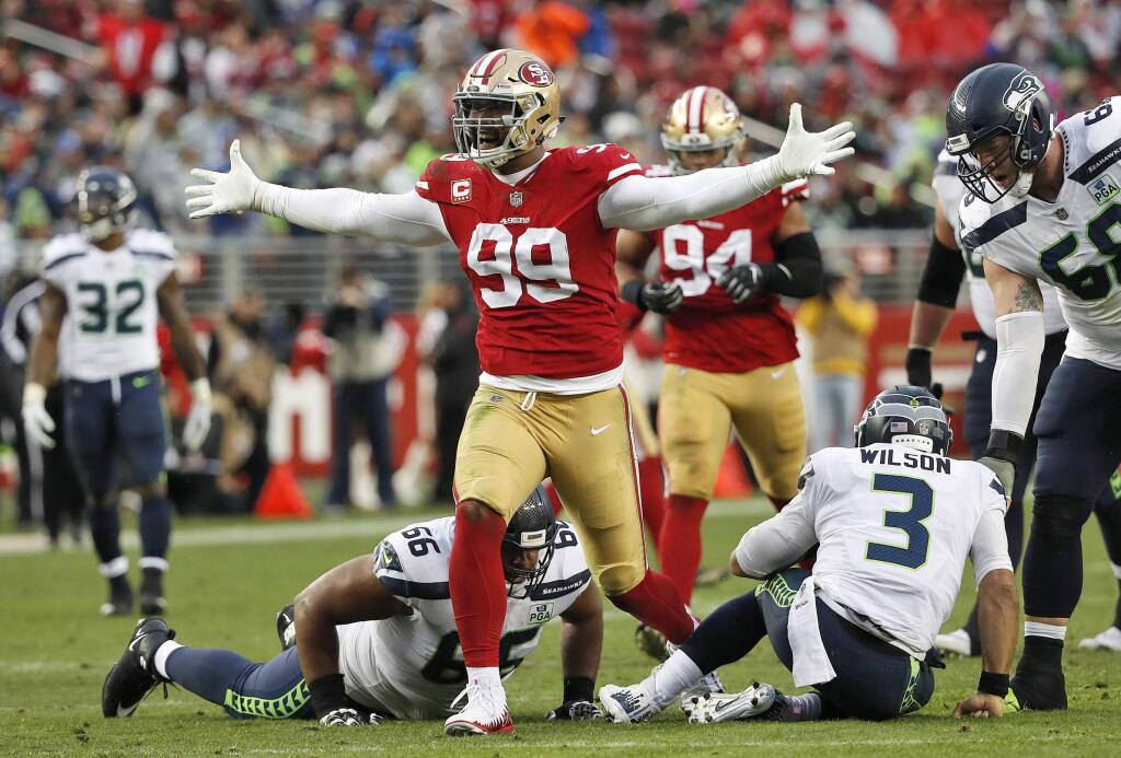 FILE - In this Sunday, Dec. 16, 2018, file photo, San Francisco 49ers defensive end DeForest Buckner (99) celebrates after sacking Seattle Seahawks quarterback Russell Wilson (3) during the second half of an NFL football game in Santa Clara, Calif. Generating pressure on the quarterback has never been a major problem for Buckner since entering the NFL in 2016. Turning that pressure into sacks, however, was missing his first two seasons with the 49ers. (AP Photo/Tony Avelar, File)