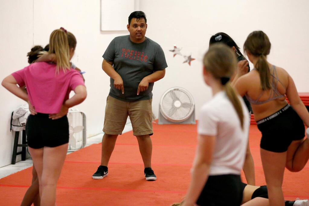 Cheer director Jose 'Chuy' Gonzalez instructs members of the TCElite competition team during practice at TCElite competitive cheer gym in Healdsburg on Thursday, Oct. 17, 2019. (Alvin Jornada / The Press Democrat)