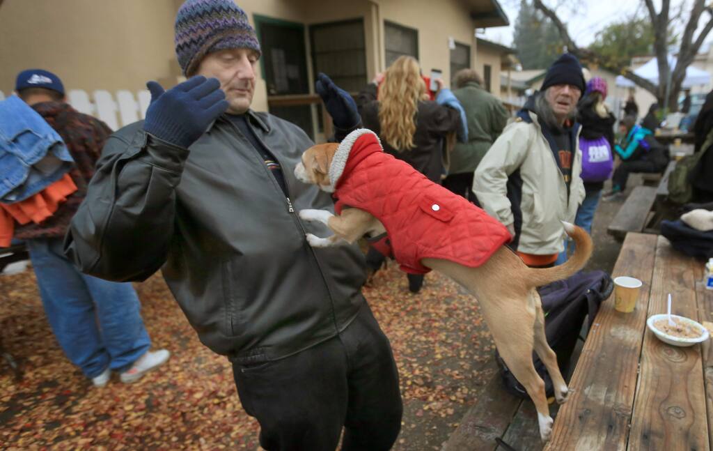 Norman Jensen motions for his dog Ozzie to jump in his arms during a Catholic Charities clothes giveaway in 2014. (KENT PORTER/ PD FILE)