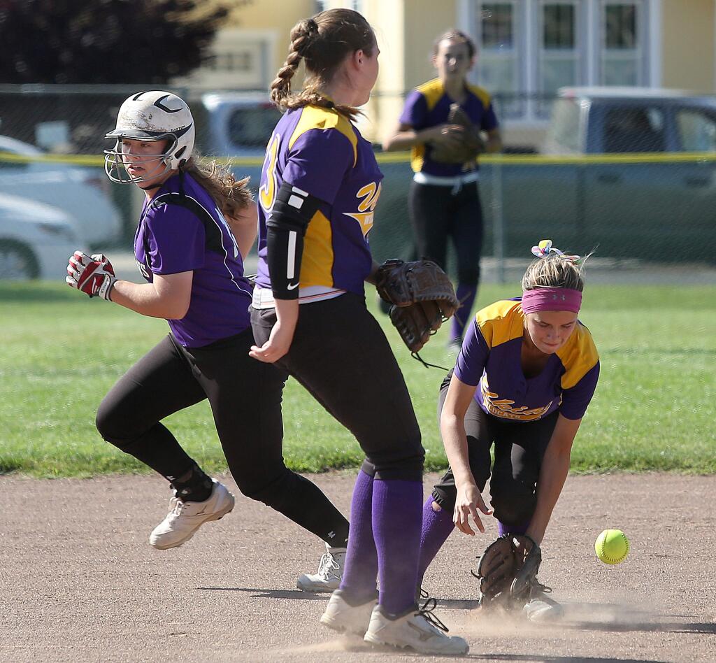 The ball gets by Ukiah's Kaylah Pardini, center, and Rylee Rickel, right, as Petaluma's Alexis Silinonte scores a run from second during the game held at Petaluma High School, Wednesday, May 27, 2015. (CRISTA JEREMIASON / The Press Democrat)