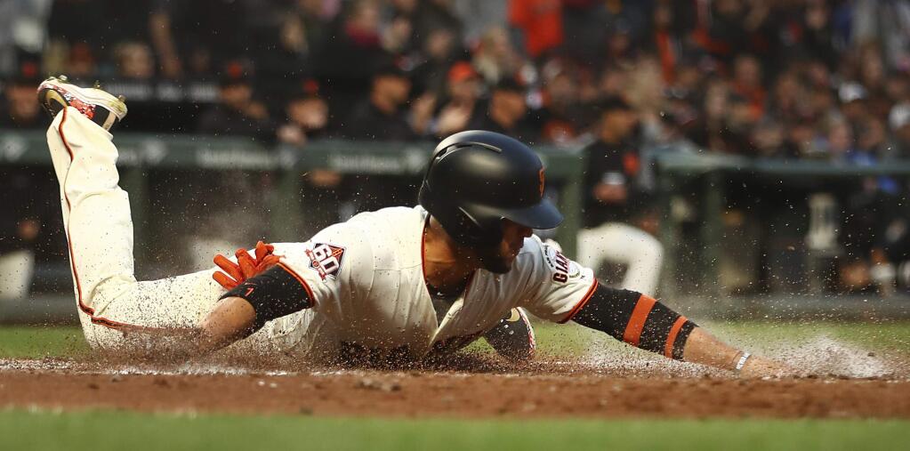 San Francisco Giants' Gregor Blanco slides to score against the Cincinnati Reds in the second inning of a baseball game Monday, May 14, 2018, in San Francisco. Blanco scored on a double by Giants' Andrew McCutchen. (AP Photo/Ben Margot)