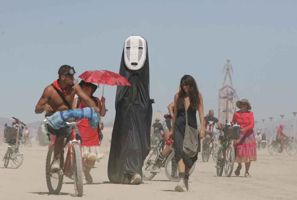In this file photo taken Thursday, Aug. 28, 2008, Burning Man participants walk on the playa at the Black Rock Desert near Gerlach, Nev. (AP Photo/Brad Horn, File)