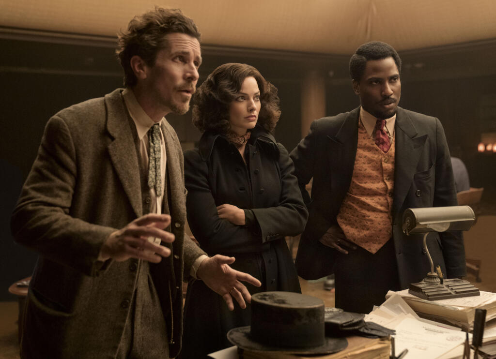 This image released by 20th Century Studios shows, from left, Christian Bale, Margot Robbie and John David Washington in a scene from "Amsterdam." (Merie Weismiller Wallace/20th Century Studios via AP)