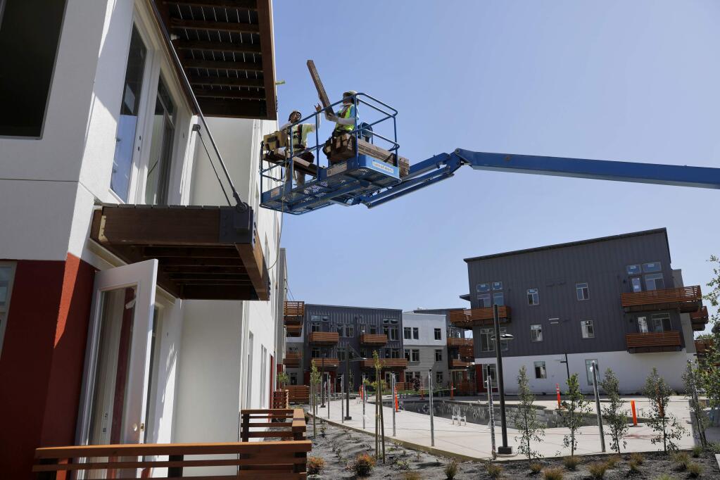 Ramon Avellar, left, and Hilario Garcia of Katerra Construction work on building a balcony as they complete new units of the Annadel apartment complex on Monday, April 30, 2018 in Santa Rosa, California . (BETH SCHLANKER/The Press Democrat)