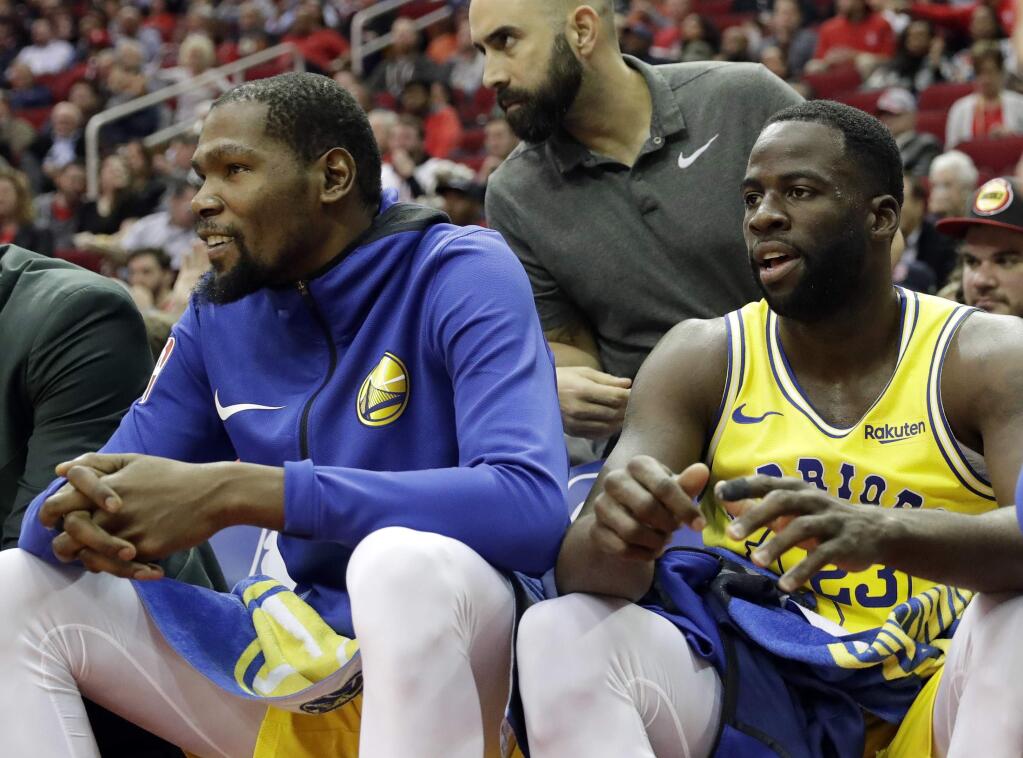 The Golden State Warriors' Kevin Durant, left, and Draymond Green sit on the bench during the first half against the Houston Rockets Thursday, Nov. 15, 2018, in Houston. (AP Photo/David J. Phillip)