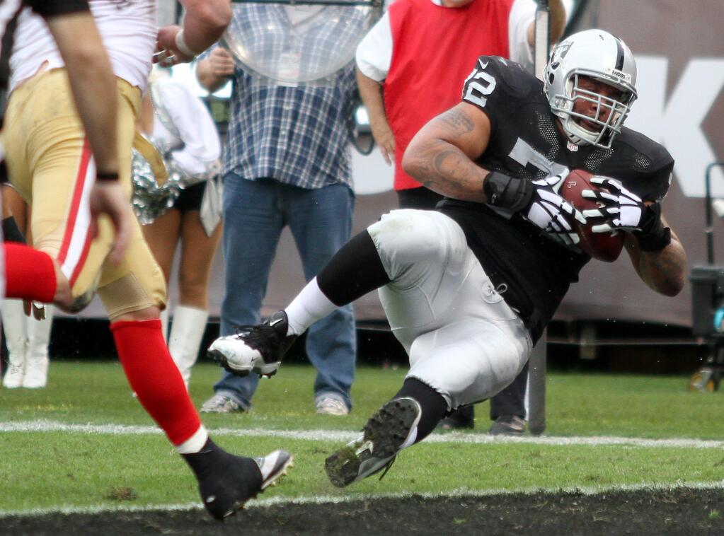 Oakland Raiders tackle Donald Penn scores on a short pass from quarterback Derek Carr in the second quarter against the San Francisco 49ers during their game in Oakland on Sunday, Dec. 7, 2014. (Christopher Chung / The Press Democrat)
