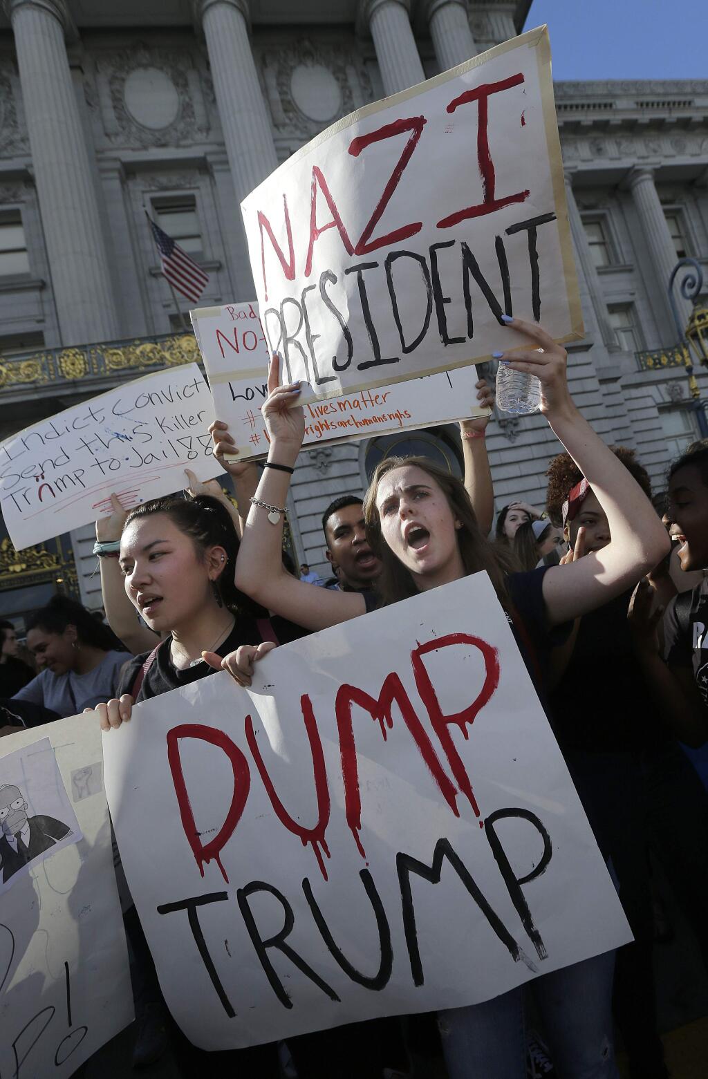 FILE - In this Nov. 10, 2016, file photo, Mission High School students Hope Robertson, right, yells as she protests with other high school students in opposition of Donald Trump's presidential election victory in front of City Hall in San Francisco. The union representing San Francisco's public school teachers is circulating a classroom lesson plan that calls President-elect Donald Trump a racist and sexist man. The United Educators of San Francisco posted the plan on its website and distributed the plan via an email newsletter. The union represents about 6,000 members. (AP Photo/Jeff Chiu, File)