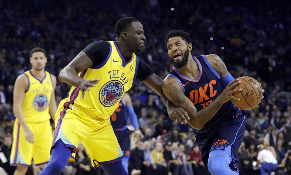 The Oklahoma City Thunder's Paul George, right, is defended by the Golden State Warriors' Draymond Green during the first half Saturday, Feb. 24, 2018, in Oakland. (AP Photo/Marcio Jose Sanchez)