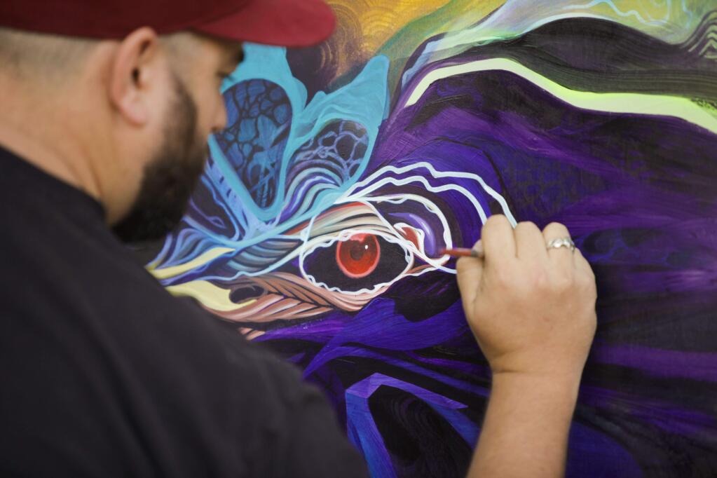 Rhett Johnston of Occidental paints a canvas in Helen Putnam Plaza during the O+Petaluma festival on Saturday, November 05, 2016. (CRISSY PASCUAL/ARGUS-COURIER STAFF)